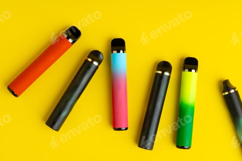 Preview: Colorful disposable electronic cigarettes on yellow background