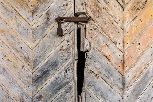Preview: old rusty padlock on the wooden door