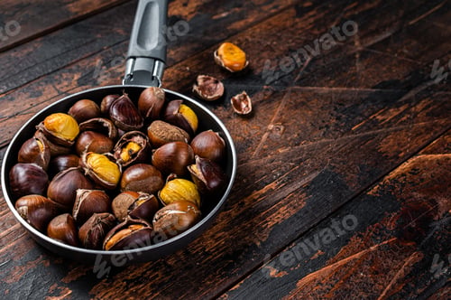 Preview: Roasted chestnuts nuts in a pan. Wooden background. Top view. Copy space