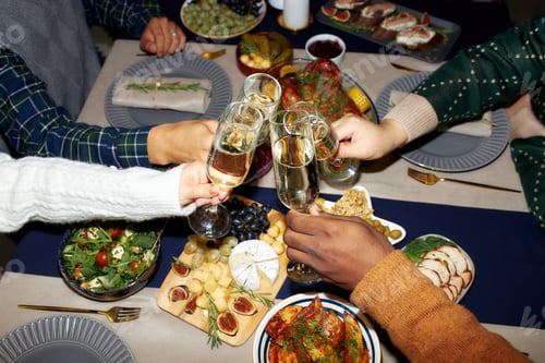 Preview: Hands of People Clinking Glasses with Champagne at Home Dinner while Celebrating Christmas