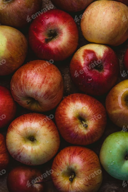 Preview: elevated view of pile of apples with water drops on wooden surface