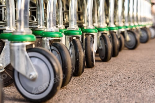 Preview: Detail of the plastic wheels of shopping carts in a supermarket lined up.