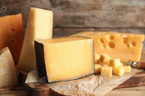 Preview: Different types of delicious cheese on table against wooden background