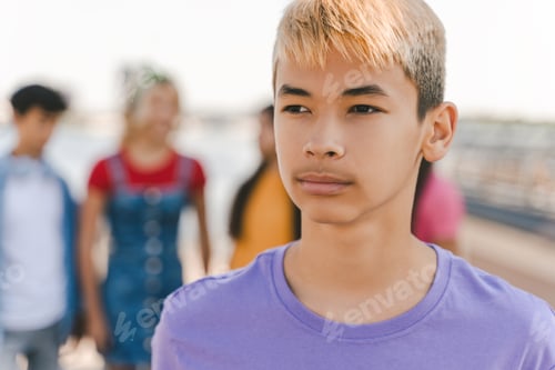 Preview: Portrait of pensive Korean teenage boy with colored hair wearing purple t shirt on street, outdoors