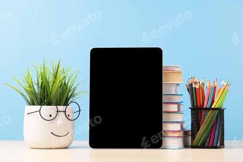 Preview: Tablet with colorful pencils and stack of books