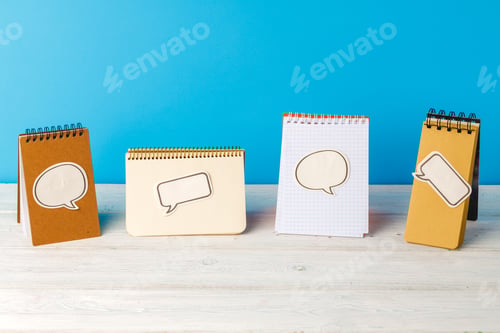 Preview: Four open spiral notepads with speech bubble stickers