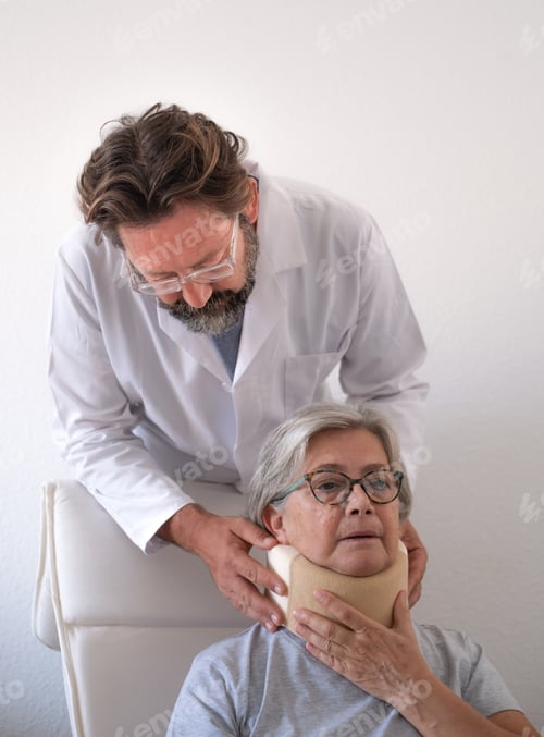 Preview: Senior woman in pain wearing a cervical collar with the assistance of her physiotherapist doctor