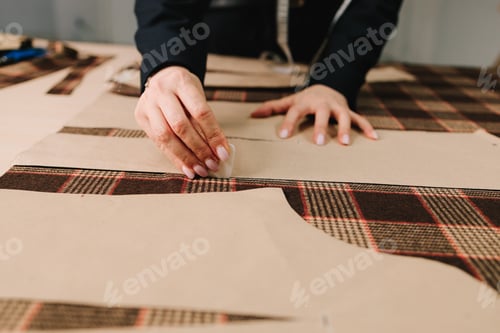 Preview: Designer marks sewing patterns on fabric with chalk for precise tailoring of apparel.