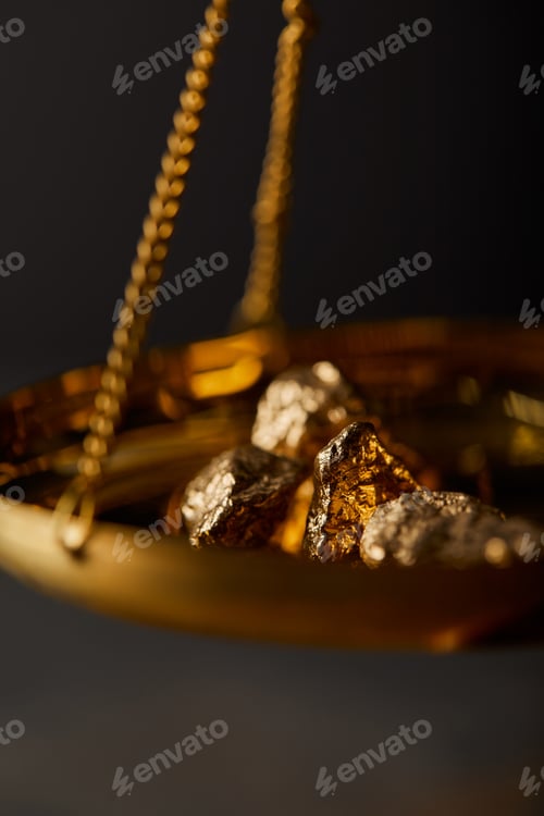 Preview: selective focus of golden stones on scales on dark blurred background
