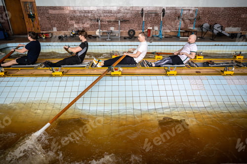 Preview: Focused determined athletes refine synchronized rowing, mastering oar control on simulator in pool