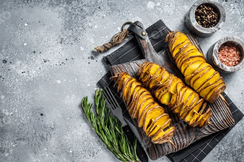 Preview: Crispy Tornado or twist potatoes chips on wooden board. Gray background. Top view. Copy space