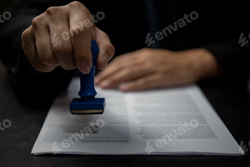 Preview: Man stamping approval of work finance banking or investment marketing documents on desk.