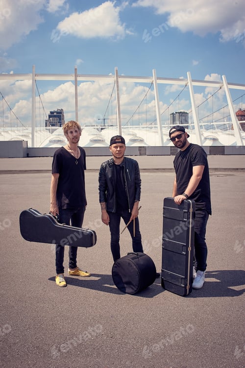 Preview: rock music band with musical instruments in cases standing on street