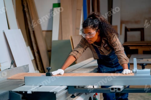 Preview: Professional carpenter woman check about cutting machine during work with wood product in workplace.