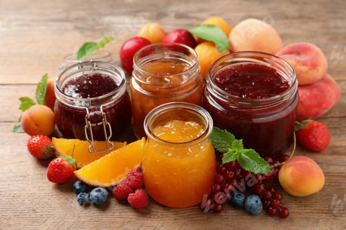 Preview: Jars with different jams and fresh fruits on wooden table