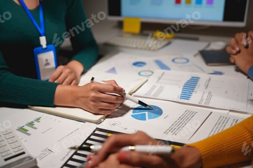 Preview: Business team working with financial data using calculators and analyzing charts on their workplace