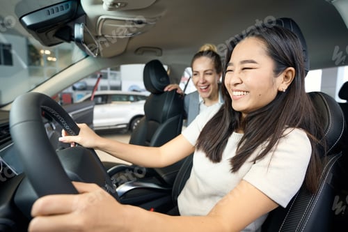 Preview: Two happy women sitting inside a car