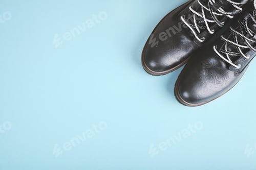 Preview: Pair of black genuine leather boots. Blue background