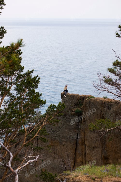 Preview: A woman on the edge of rock