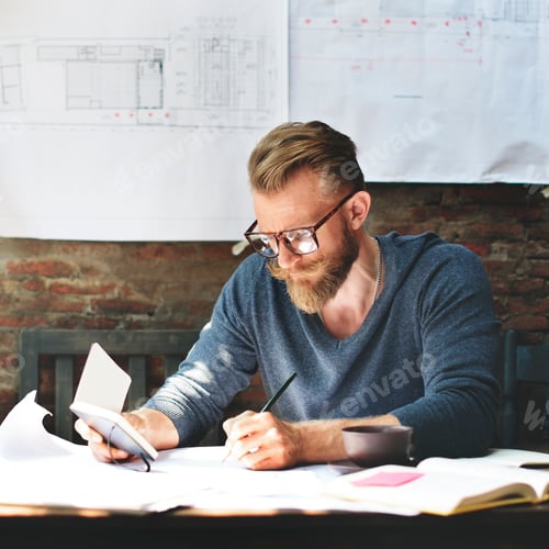 Man Working With Blueprints and Notes