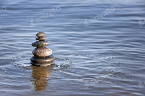 Preview: Stack of dark stones in sea water, space for text. Zen concept