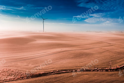 Preview: Wind turbine and brown field. Agriculture and alternative energy.