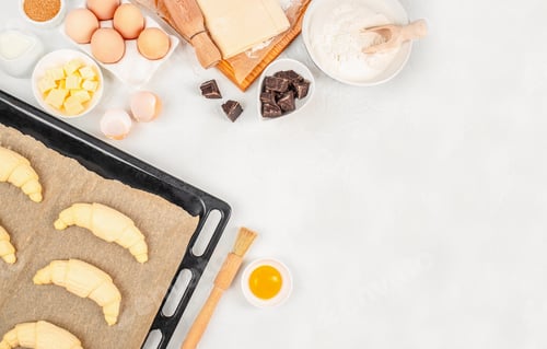 Preview: Raw croissants on baking tray with pastry ingredients and chocolate