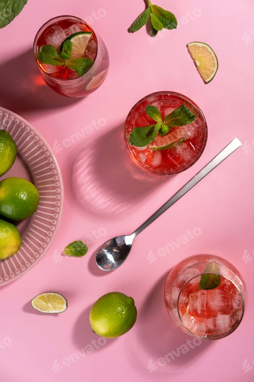 Preview: Strawberry mojito. Cocktail with rum, mint, lime and ice in a glass on a pink background.