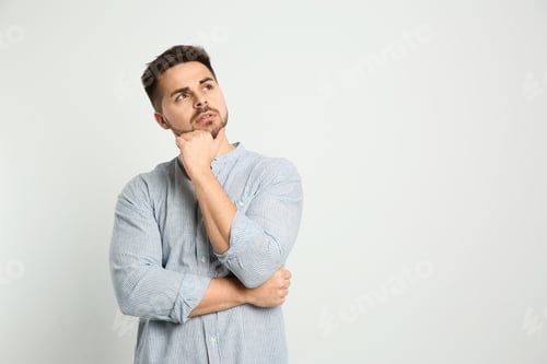 Preview: Pensive man on light background, space for text. Thinking about answer to question