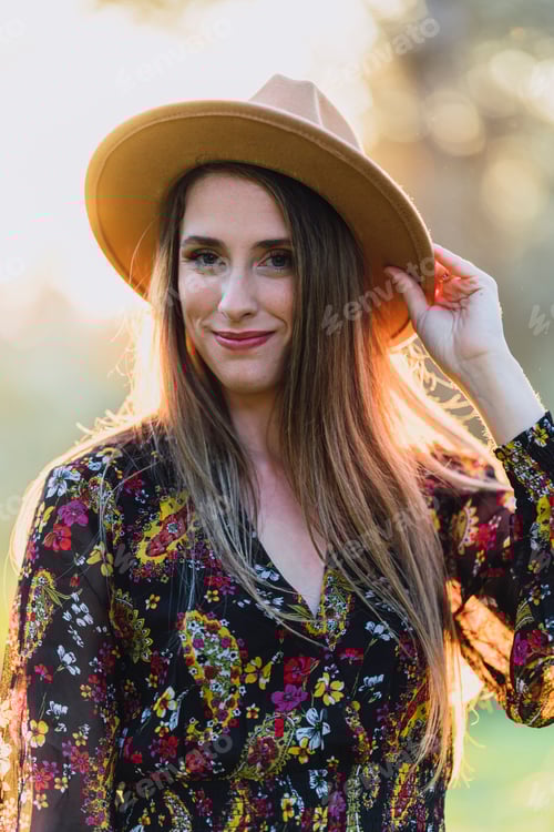 Preview: Portrait of a young smiling woman in a wide-brimmed hat looks at the camera.