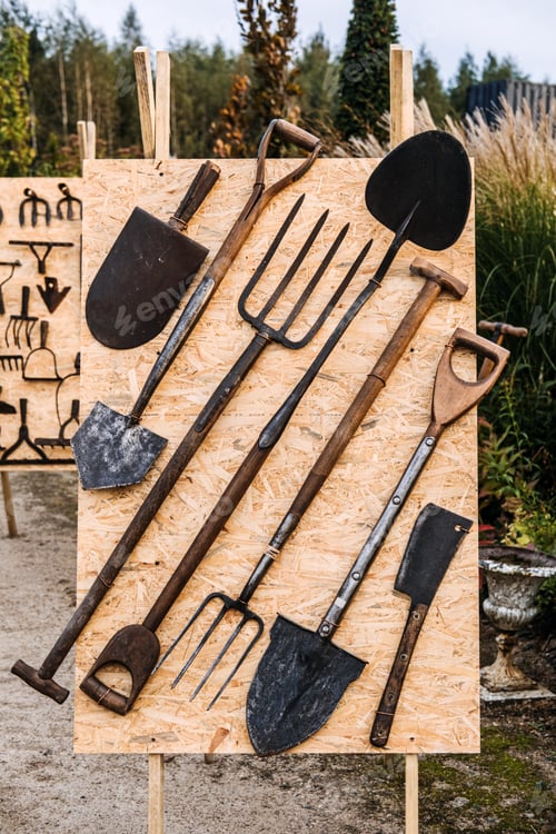 Preview: A display board featuring vintage farming tools including shovels, pitchforks,