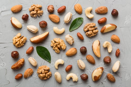 Preview: Composition of nuts , flat lay - mix hazelnuts, cashews, almonds on table background.