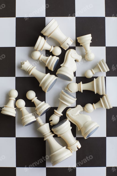 Chess Pieces Scattered on a Checkered Game Board