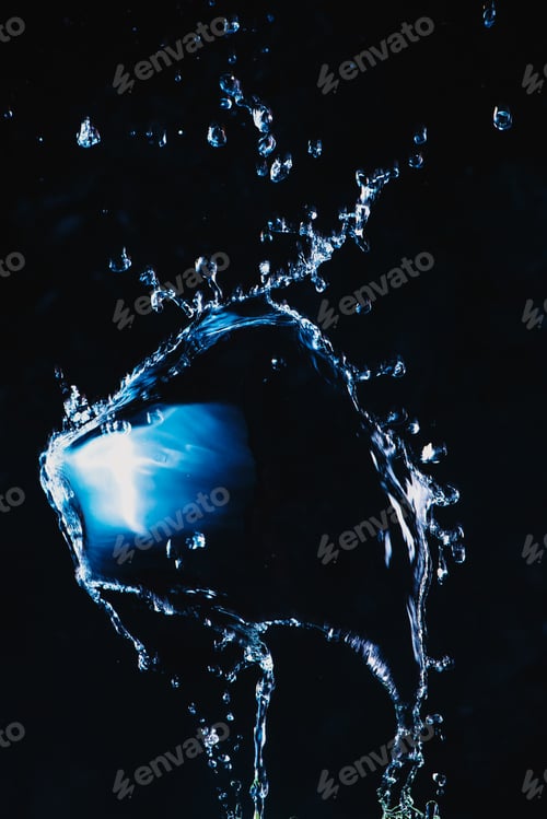 Preview: Dynamic splash of water on a dark background. Flying transparent liquid with a shiny surface. High