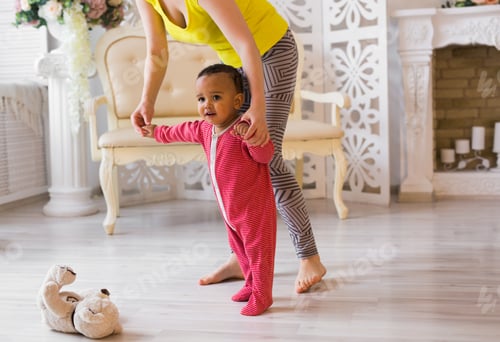 Preview: Cute little mixed race baby learning to walk, mom is holding his hands
