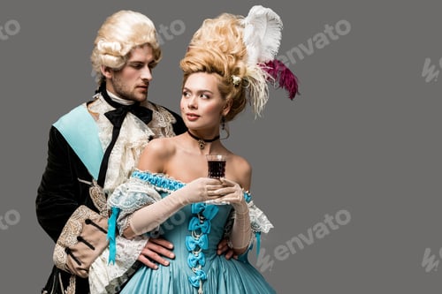 Preview: victorian gentleman in wig looking at beautiful woman with wine glass isolated on grey