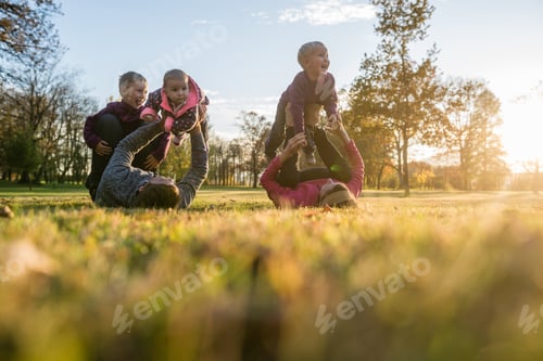 Preview: Happy young family of five playing in autumn park