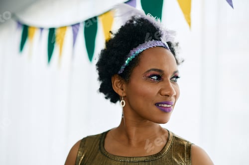Preview: Portrait of black Mardi Gras woman with glittering make-up at home.