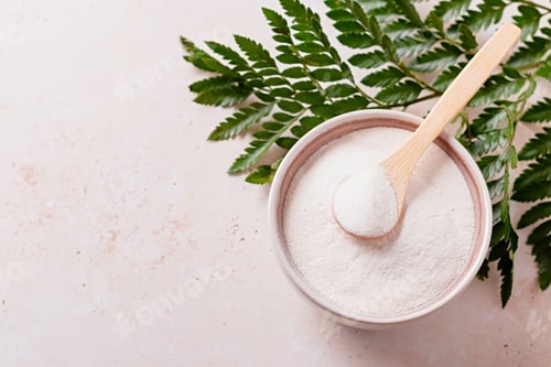 Preview: Collagen powder and spoon on beige stone background, top view