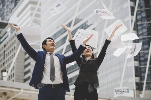 Preview: Business people are throwing up papers, while standing in front of office building.