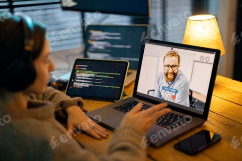 Preview: Woman talking online with a male colleague at home office