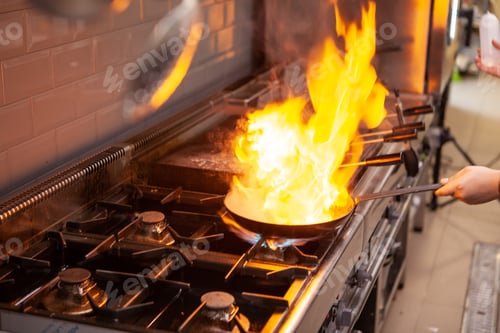 Preview: Chef cooking with flame on his restaurant kitchen.