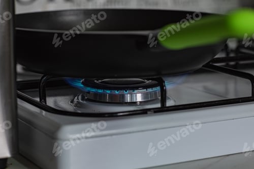 Preview: Frying pan with sauce on the stove over high heat.