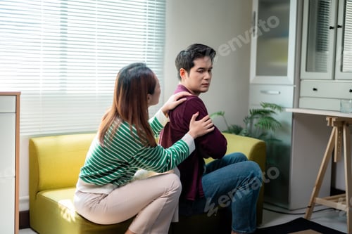 Preview: Woman comforting sad man sitting on sofa at home