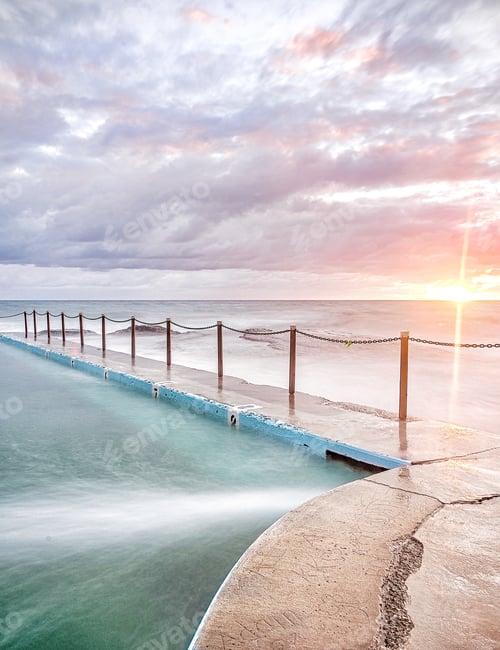 Preview: A pastel sunrise over an ocean pool is a beautiful tranquil start to the day