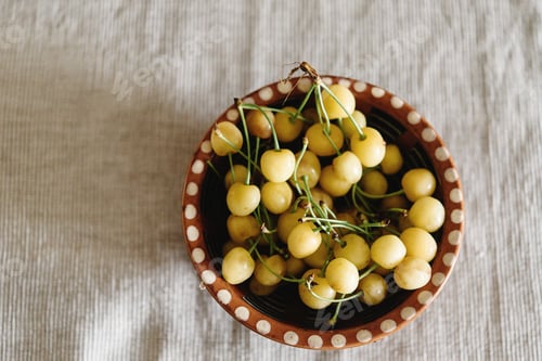Preview: delicious yellow cherries in old bowl on rustic background