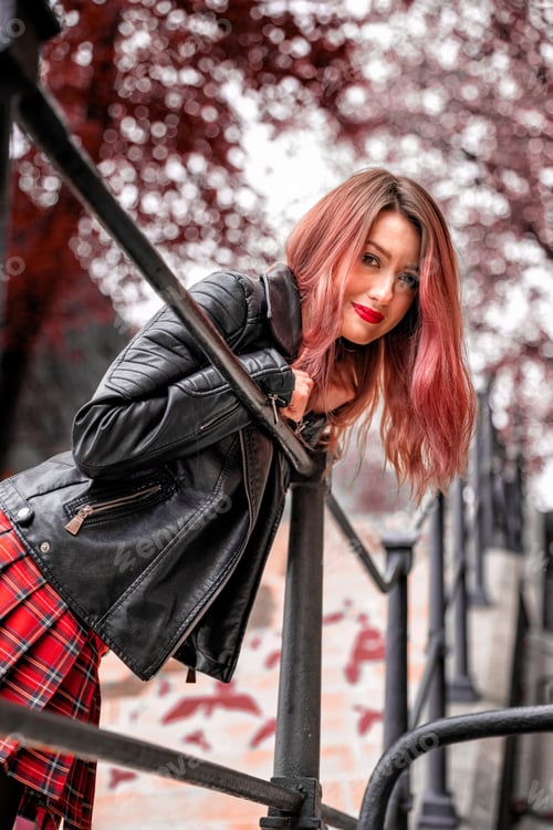 Preview: an attractive woman with a pleasant smile stands on a city street, leaning on the railing