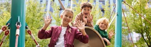 Preview: Joyful children playing on a slide in a vibrant autumn park filled with colorful leaves