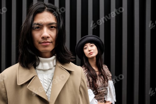 Preview: Fashionable asian couple posing against modern background