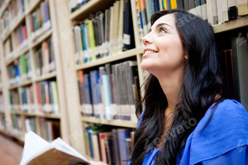 Preview: Thoughtful Female Student At The Library Holding A Book